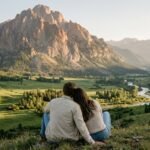 Casal contemplando a harmonia da paisagem, a conexão entre o vale e montanha.